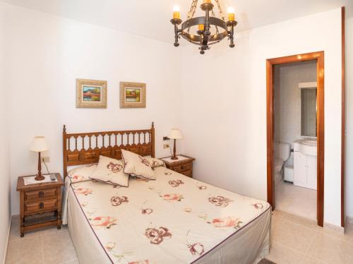 a bedroom with a bed and a chandelier at Casa Ravel in Silleda