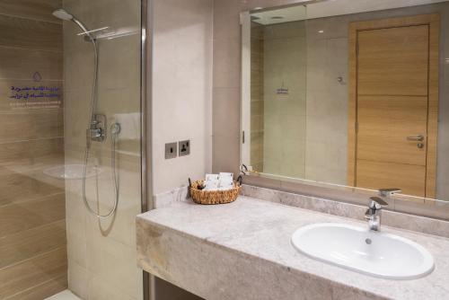 a bathroom with a sink and a shower at Dara Al Rayan in Riyadh