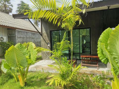 ein Haus mit Glastüren und Pflanzen im Hof in der Unterkunft Natai House in Natai Beach