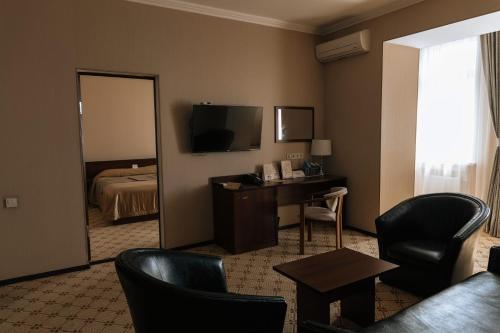 a hotel room with a bed and a desk and a mirror at Medeu in Kostanay