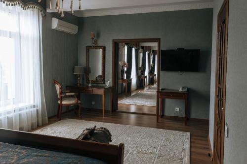 a bedroom with a bed and a television and a mirror at Medeu in Kostanay