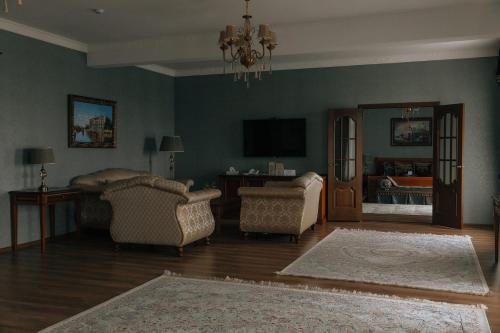 a living room with two chairs and a flat screen tv at Medeu in Kostanay