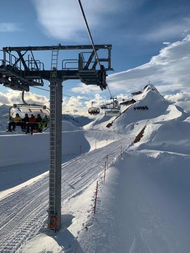 a ski lift with people on it in the snow at K-Appartements Klösterle in Klösterle am Arlberg