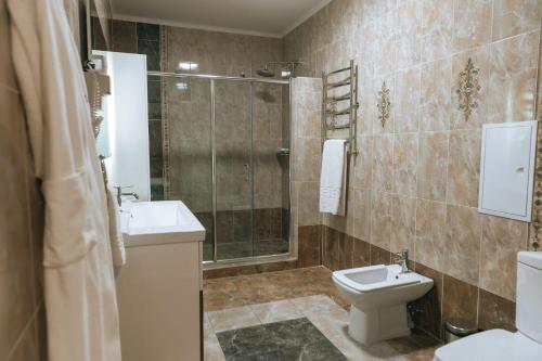 a bathroom with a toilet and a sink and a shower at Medeu in Kostanay