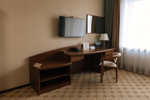 a desk in a hotel room with a phone on it at Medeu in Kostanay