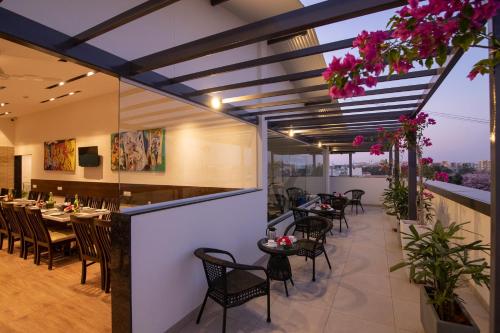 a restaurant with tables and chairs on a balcony with pink flowers at Mojatel By Icon in Bangalore