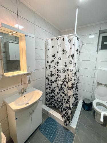 a bathroom with a shower curtain and a sink at Katarina Rooms in Novi Kneževac