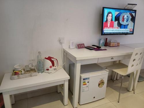 a room with a desk and a tv on a wall at Beach Grand & Spa Premium in Hulhumale