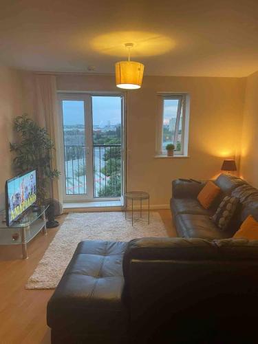 a living room with a couch and a tv at 3 Bedroom Beautiful Apartment in Manchester