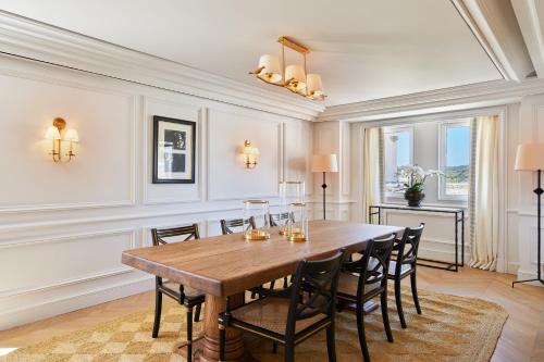 a dining room with a wooden table and chairs at Airelles Château de la Messardière in Saint-Tropez