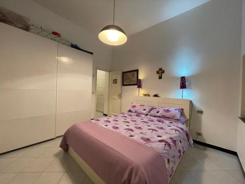 a bedroom with a bed with a pink comforter at RAPALLO centro storico a due passi dal mare con ascensore in Rapallo