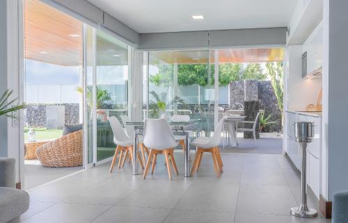 a dining room with white chairs and a table at Hyde Park Lane Villas in Puerto del Carmen