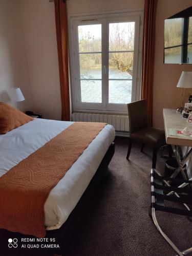 a bedroom with a bed and a desk and a window at Hostellerie de Pavillon Saint-Hubert in Gouvieux