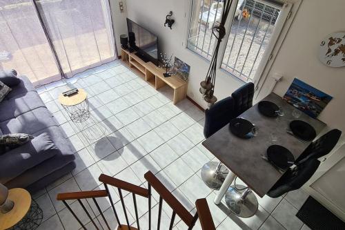 uma vista aérea de uma sala de estar com uma mesa em Proche mer appartement avec jardin,place parking. em Elne