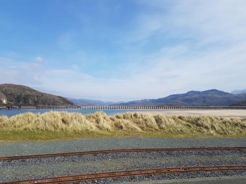 a body of water with a bridge in the background at 48 Glan Y Mor in Fairbourne