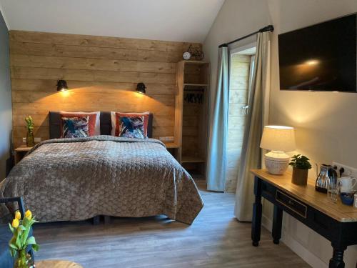 a bedroom with a bed with a wooden wall at Bed and Breakfast Vechtdals Mooiste in Giethmen