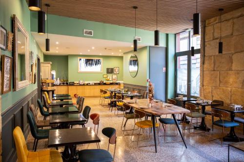 a restaurant with wooden tables and chairs and green walls at Hôtel Royal in Montpellier