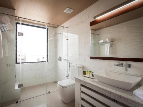 a bathroom with a sink and a toilet and a mirror at The Ocean Colombo in Colombo
