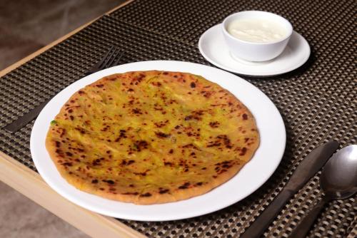 a cheese pizza on a plate on a table at Athome Comforts Panjim Donapaula in Panaji