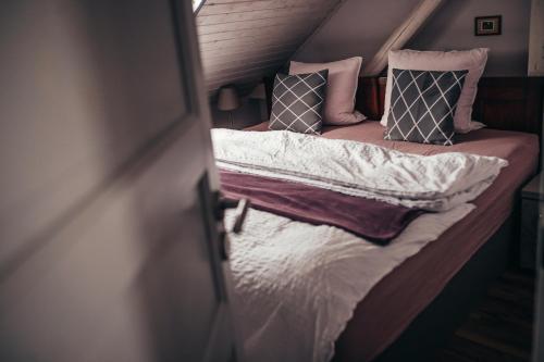 a bed with pillows on it in a room at Apartmány Rudík in Železná Ruda