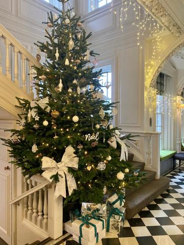 a christmas tree in a hallway with presents at Barnett Hill Hotel in Guildford