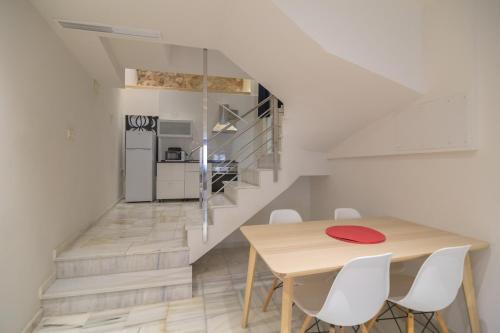 a dining room with a table and a staircase at Hotel La Milagrosa in Alicante