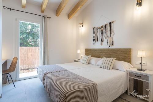 ein weißes Schlafzimmer mit einem großen Bett und einem Fenster in der Unterkunft Casa obac in Sa Pobla