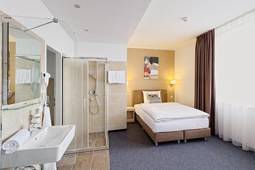 a hotel room with a bed and a bathroom at BO Hotel Hamburg in Hamburg