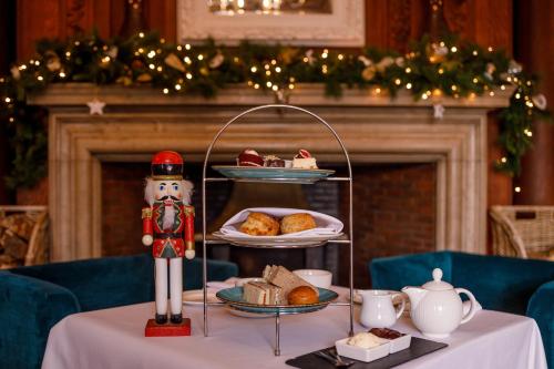 a table with a plate of pastries and a nutcracker on a table at Barnett Hill Hotel in Guildford
