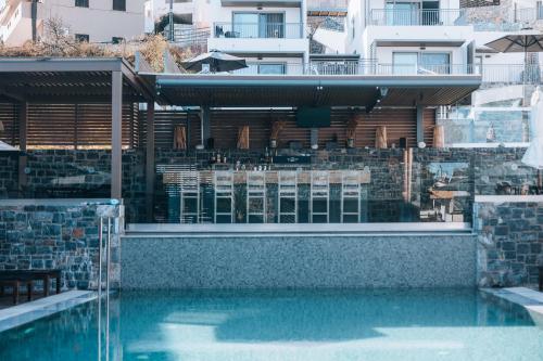 a swimming pool in front of a building at Seascape Luxury Residences in Agia Pelagia