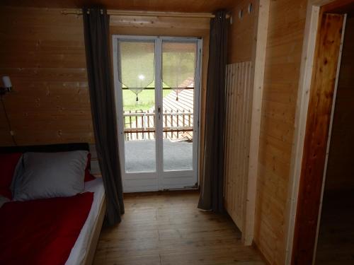 a room with a door leading to a porch at Au Cheval Blanc in Asuel