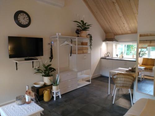 a living room with a tv and a kitchen at Logies De Houtdijk in Harich