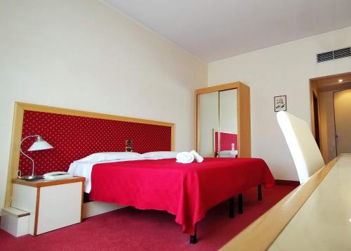 a bedroom with a large bed with a red headboard at Hotel Palace Masoanri's in Reggio Calabria
