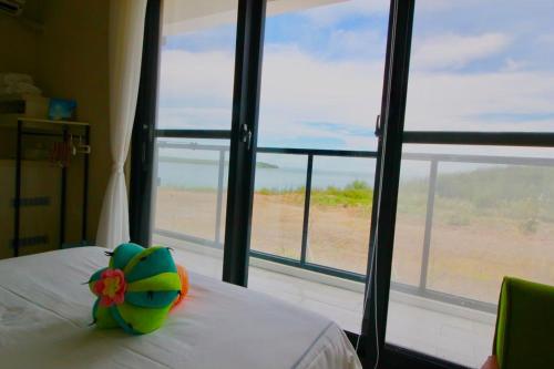 a bed with a flower pillow on it in front of a window at 嵵裡仙人掌海景民宿Ocean view room in Magong