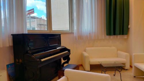 a living room with a piano and a chair at Hotel Palace Masoanri's in Reggio Calabria