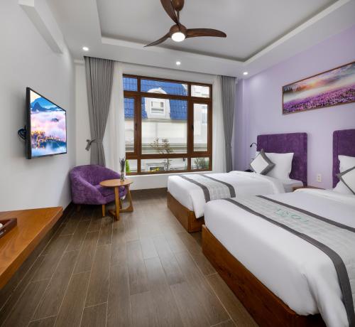 a hotel room with two beds and a window at Lasol Boutique Hotel in Da Lat
