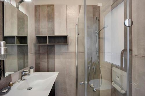 a bathroom with a sink and a glass shower at Victoria Apartments Fil Rouge in Diano Marina