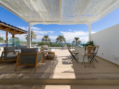 a patio with chairs and tables and a view of the ocean at Pasitoblanco Porto Mare 45 Seaview Villa prívate heated pool in Pasito Blanco