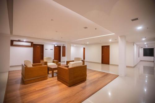 a large room with chairs and tables and a tv at Hotel Niya Regency in Trichūr