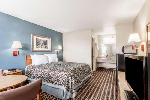 a hotel room with a bed and a kitchen at Days Inn by Wyndham Nashville N Opryland/Grand Ole Opry in Nashville