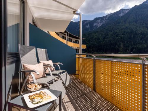a balcony with chairs and a table with food on it at Vivea Hotel Bad Bleiberg in Bad Bleiberg