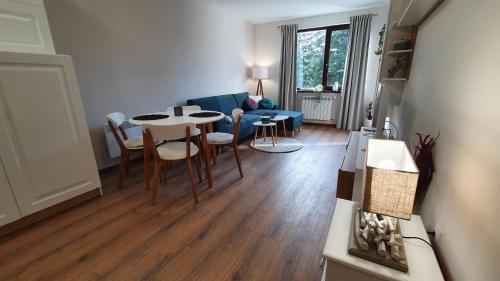 sala de estar con mesa, sillas y sofá en Borovets Holiday Homes en Borovets