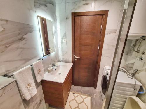 a bathroom with a sink and a toilet and a mirror at Royal apartman Zlatibor in Palisat