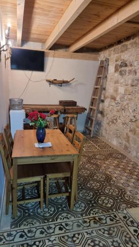 a dining room with a wooden table and a ladder at Boutique Agam Hahoresh - בוטיק אגם החורש in Haifa