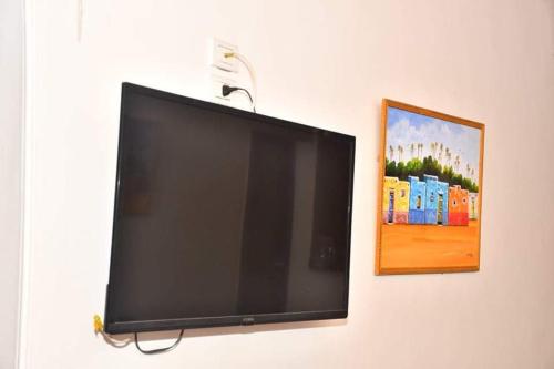 a flat screen tv hanging on a wall with a picture at Om-Abdallah in Aswan
