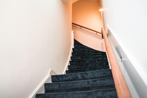 a staircase in a building with black carpet at Limehome The Hague Keizerstraat in Scheveningen