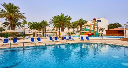 a swimming pool with lounge chairs and a playground at Globales Los Delfines in Cala en Blanes