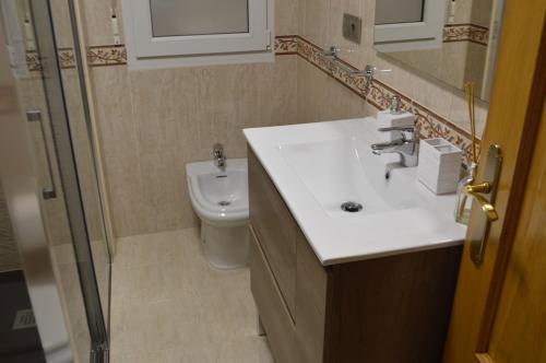 ein Bad mit einem Waschbecken und einem WC in der Unterkunft Las Palmeras in Caldas de Reis