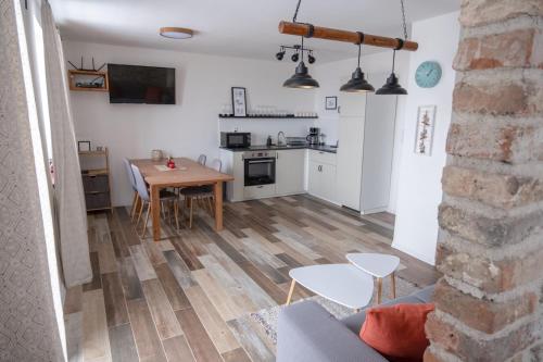 a living room with a table and a kitchen at Jachovka in Nová Ves v Horách