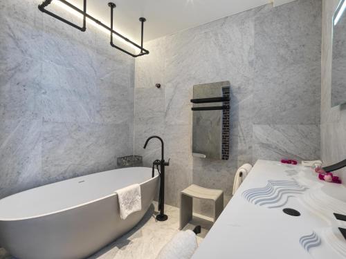 a bathroom with a white tub and a table at Snow Lodge Hotel Courchevel 1850 in Courchevel